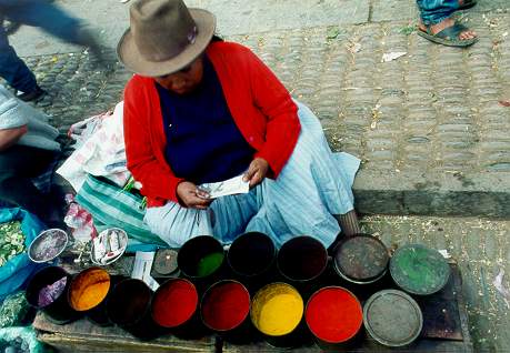 Vegetable dye vendor with her wares at Pisac market, Cusco, Peru.
